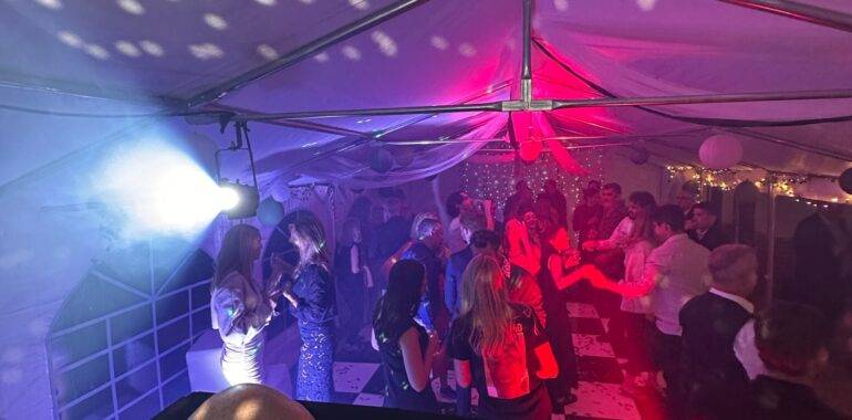 Garden party with festoon lighting, photo booth and guests enjoying the evening