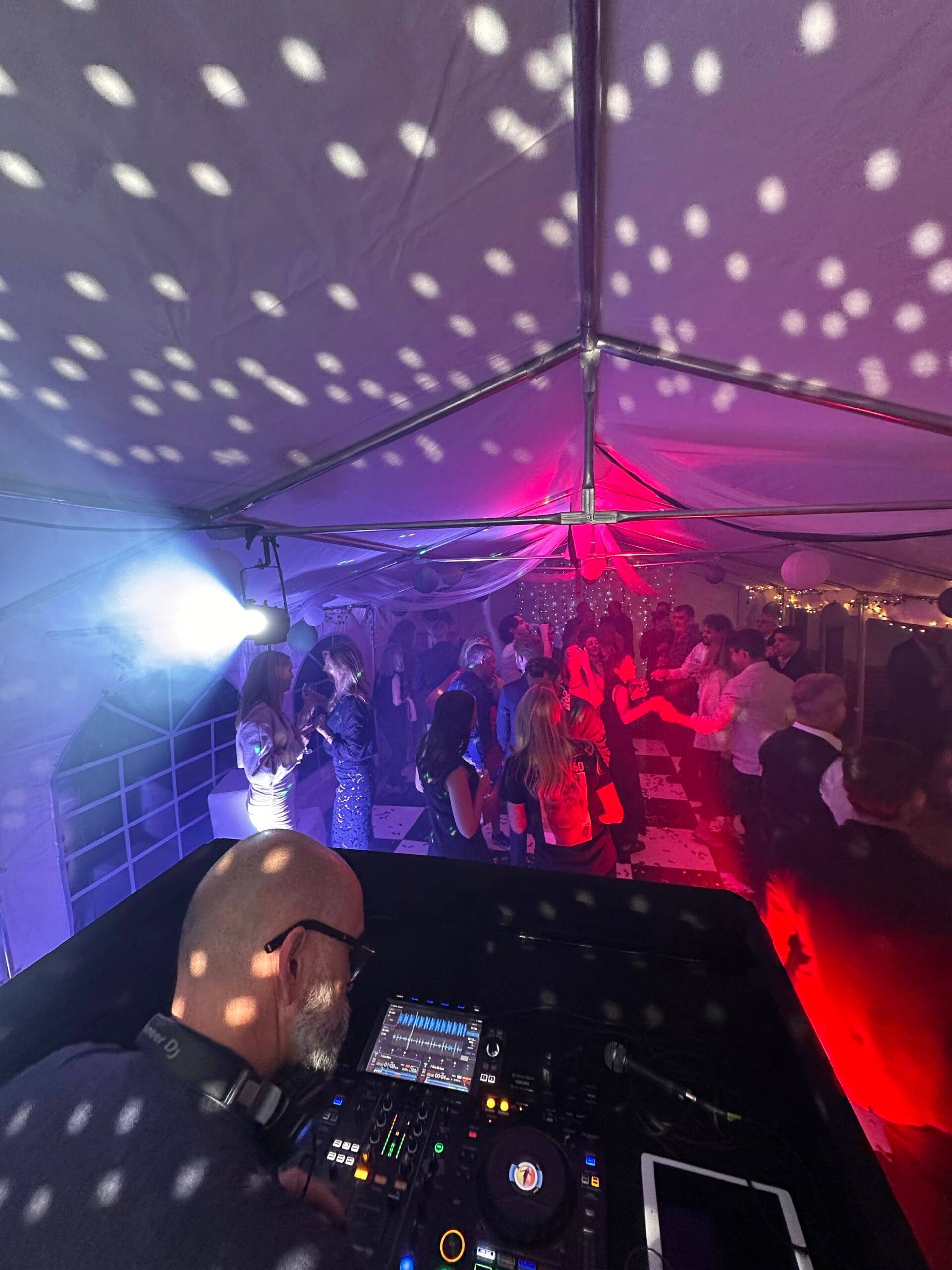 Garden party with festoon lighting, photo booth and guests enjoying the evening